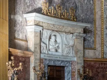 Marble altar with a relief of Saint Robert Bellarmine, flanked by angel figures and golden candelabras.