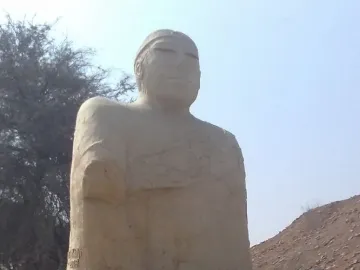 Upper torso of the Priest-King statue showing a bearded man with a forehead band and draped cloak patterns.