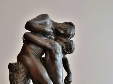Sakuntala, a dark bronze sculpture of two nude figures in an embrace, with one standing and supporting the other kneeling.
