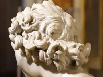 Damned Soul marble bust shown from the back and right side, with tightly curled hair and the head bowed on a marble pedestal.