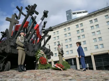 The Monument to the Fallen and Murdered in the East with crosses and Polish flags, flanked by soldiers and floral wreaths during a commemorative ceremony.