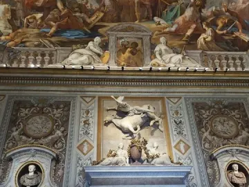 The Rape of Proserpina sculpture seen through a marble archway, with the figure of Pluto lifting Proserpina and a dog nearby.