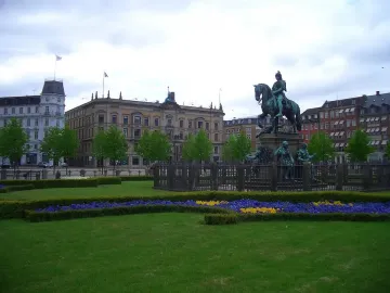 Christian V equestrian statue showing an armored rider on a rearing horse atop an ornate pedestal with sculptural figures.