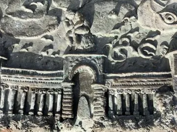 Close-up of the San Francisco Fountain relief sculpture with an arched colonnade, flanking towers, clouds, and a seated figure.