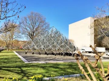 Delta Solar, a pyramid-shaped stainless steel sculpture with reflective panels in a grassy park