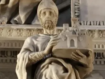 Saint Petronius stone statue in robes and a mitre, holding a miniature walled city.
