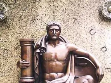 Bronze relief of a muscular seated male figure holding a column and resting on a shield with a lion base.