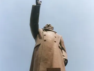 Bronze monument Long Live the Victory of Mao Zedong Thought showing a raised-arm figure above smaller bronze figures at the base