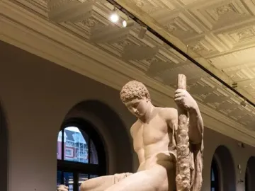 Theseus and the Minotaur marble sculpture showing a nude man seated over a defeated bull-headed creature