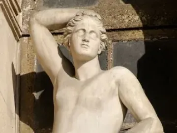 Apollino, a nude young male statue with one arm raised and a quiver beside him.