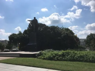 Benito Juarez statue standing on a pedestal with his right arm extended and pointing forward.