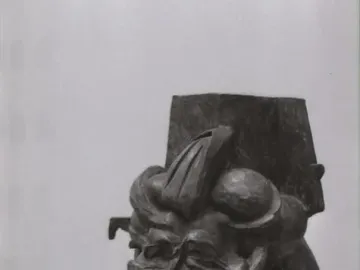 L\'antigrazioso, a dark textured abstract bust sculpture on a wooden base and pedestal.