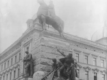 Crowd gathered in front of the Grunwald Monument, with an equestrian statue and bronze warrior figures on the pedestal.