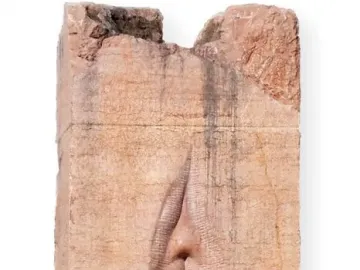 Pi-Chacán stone sculpture with a vertical vulva-like opening and subtle facial features at the top.