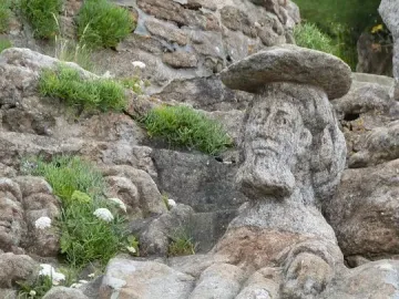 Rothéneuf Sculpted Rocks showing a bearded man carved into granite with a flat hat.