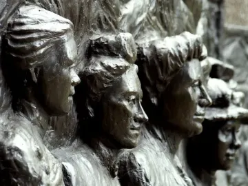 Close-up of a bronze relief on the Kate Sheppard National Memorial showing several women’s faces in profile.
