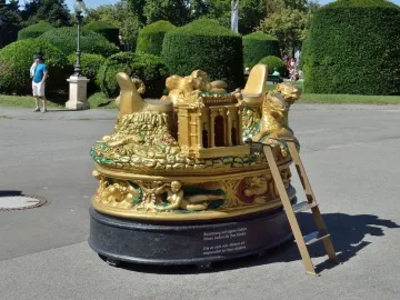 The Cellini Salt Cellar, a large ornate golden sculpture with many figures and a central architectural form on a dark base.