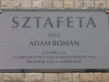 Plaque for Sztafeta with the year 1955, Adam Roman’s name, and Polish biographical text.