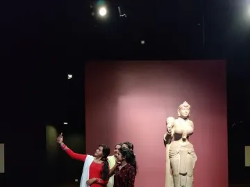 Didarganj Yakshi stone sculpture standing on a pedestal, with a broken left hand and jewelry details.