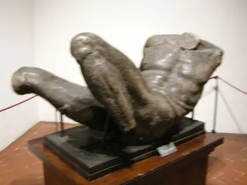 River God sculpture showing a large muscular male torso lying horizontally on a dark base.