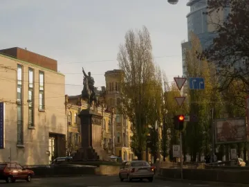 The Monument to Mykola Shchors, an equestrian statue on a tiered stone pedestal at a city intersection.