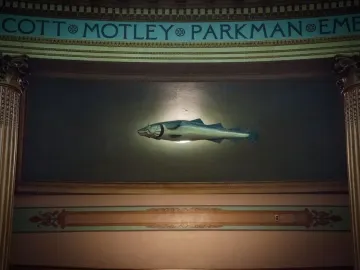 The Sacred Cod sculpture suspended between ornate pillars in the Massachusetts State House chamber.