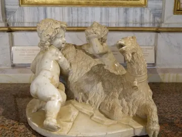 The Goat Amalthea sculpture showing two plump child figures with a shaggy goat, one kneeling on its back and another covering its eyes.