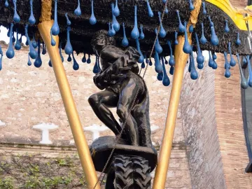 Rainy Taxi sculpture with two grappling figures beneath hanging blue teardrops