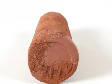 Reddish-brown funerary cone with a partially preserved circular impression and relief carvings on one flattened end.