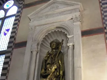 Saint Louis of Toulouse statue in an ornate stone niche with columns and a pediment.