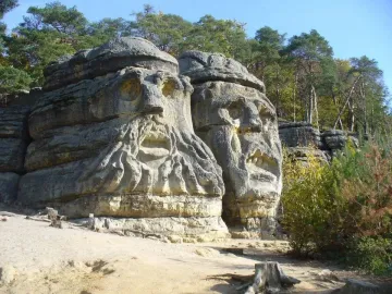 The Devil\'s Heads sandstone carvings, with two massive carved faces in a forest setting.