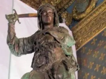 Judith and Holofernes bronze sculpture with a raised sword over a slumped figure and severed head