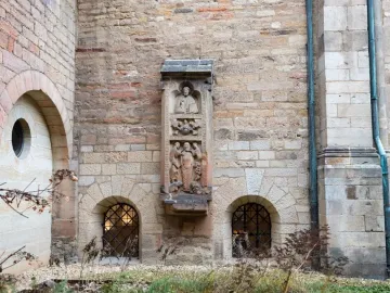 Tomb of Bruno the Priest carved in relief on a tall stone monument set into a church wall.