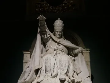 White marble statue of Pope Clement XIV from his tomb, seated in elaborate robes with one arm raised.