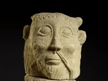 Bicha de Balazote stone sculpture showing a bearded human-like head with horn-like protrusions