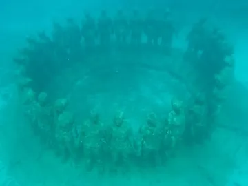 Molinere Underwater Sculpture Park with human-like sculptures arranged in a circle on the seabed