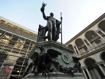 Napoleon as Mars the Peacemaker bronze statue on an ornate pedestal in a courtyard, with classical buildings behind it.