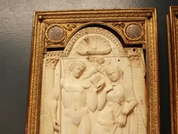 Queriniano Diptych ivory relief panel with a male and draped female figure under an arch, flanked by columns and a small winged figure.