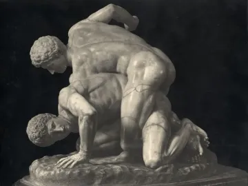 Classical marble sculpture of two wrestlers locked in a struggle, one atop the other against a dark background.