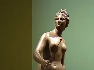 Diana bronze sculpture of a nude female figure holding an arrow and bow in a dynamic pose.