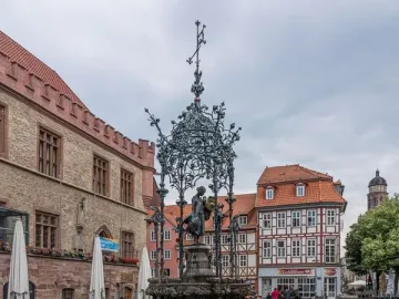 Gänseliesel Fountain with a bronze girl sculpture under an ornate canopy in Göttingen\'s town square.