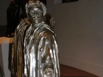 Bronze sculpture of Jean de Fiennes by Auguste Rodin, shown in a draped cloak with one hand holding a ring-like object.