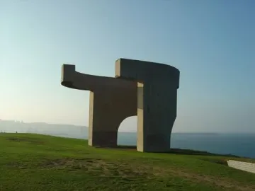 Elogio del Horizonte concrete sculpture on a grassy hill overlooking the sea