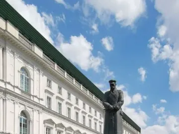 Józef Piłsudski Monument on a dark granite pedestal with red and white wreaths at its base.