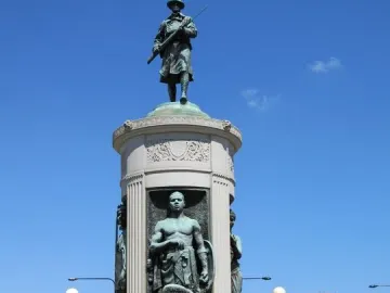 Victory Monument with bronze statues, including a soldier atop the monument and figures in lower niches.