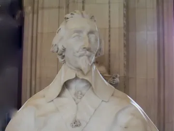 Bust of Cardinal Richelieu in white marble, showing curly hair, a mustache, a pointed beard, and a draped cape with a hanging cross medallion.