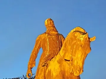 Leopold II equestrian statue in warm golden light against a twilight sky