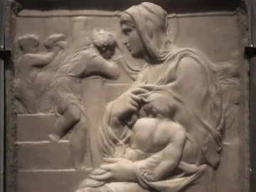 Madonna of the Stair stone relief showing a seated woman holding a child, with smaller figures on the stairs behind them.