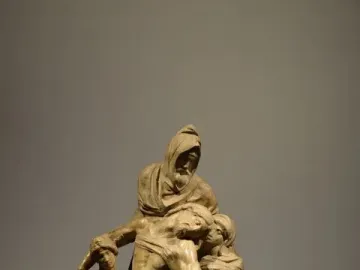 Michelangelo’s The Deposition marble sculpture showing the dead Christ supported by three robed figures.