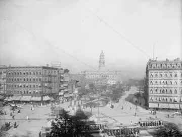 Michigan Soldiers\' and Sailors\' Monument in a busy Detroit square with streetcars, pedestrians, and horse-drawn carriages